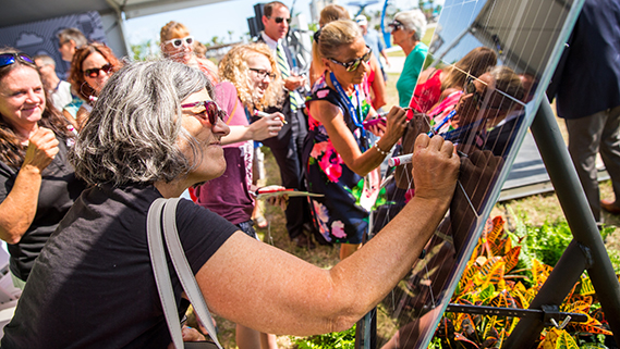 A group of people in Port Canaveral signing a solar panel