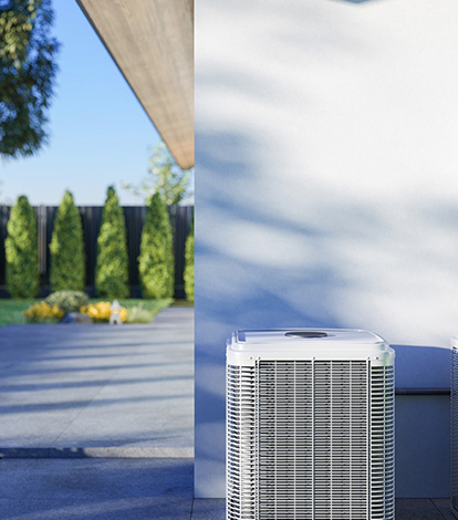 an a/c unit outside by a concrete wall
