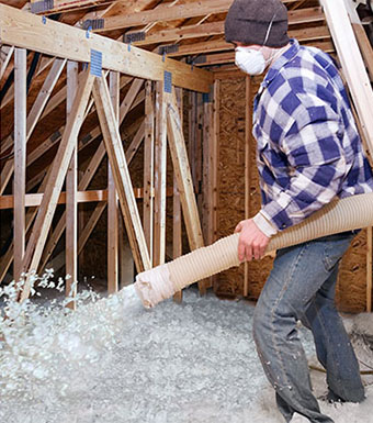 a contractor filling ceiling space with insulation