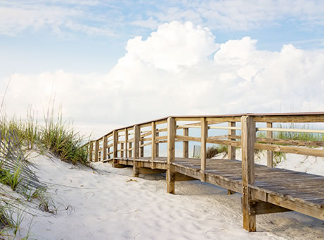 wooden boardwalk over white sand dunes at Pensacola Beach, Florida